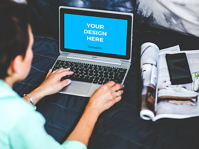 Woman working on small laptop in bed