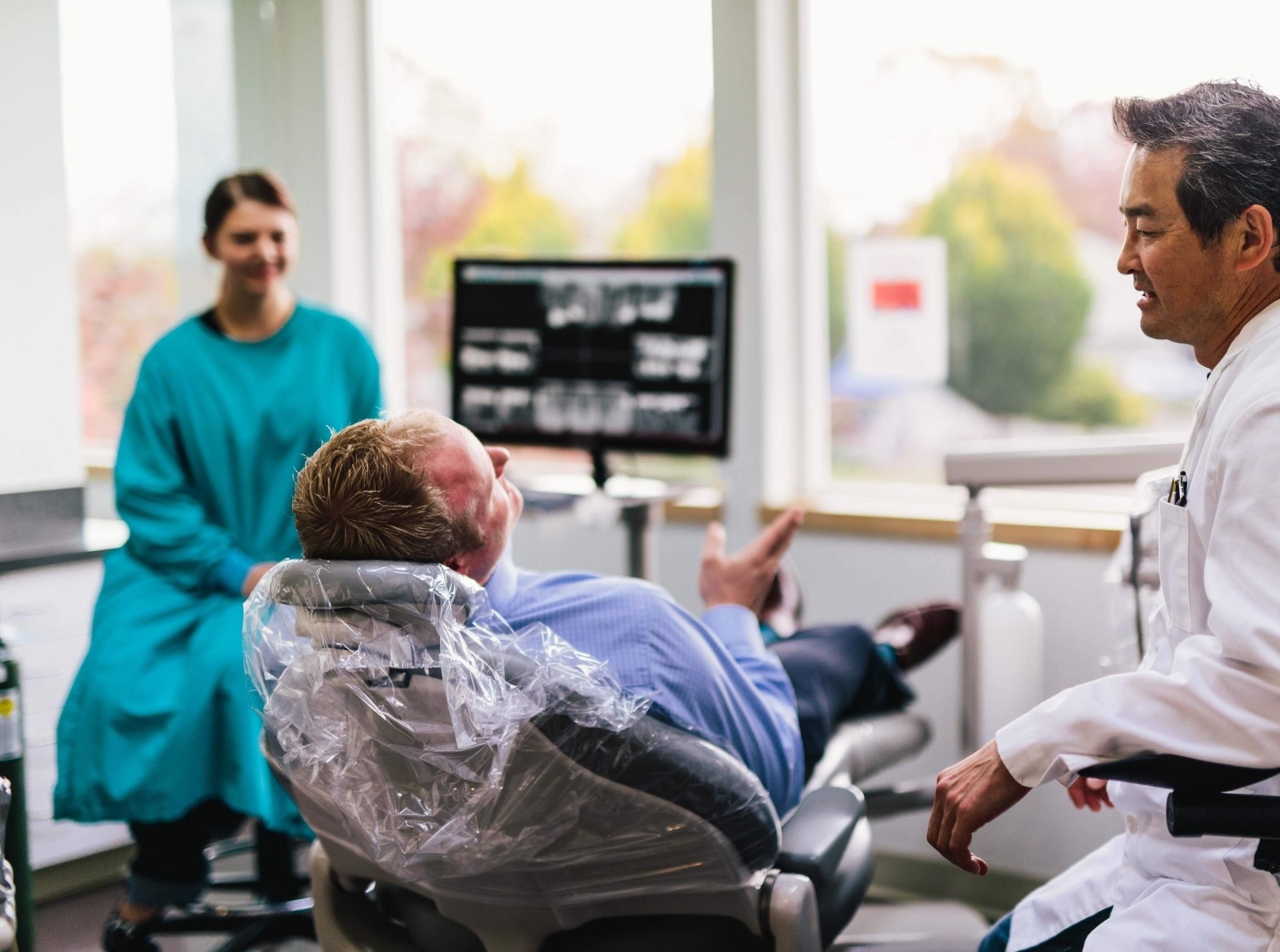 Oregon City emergency dentist Dr. Sean Kim talking to patient at by