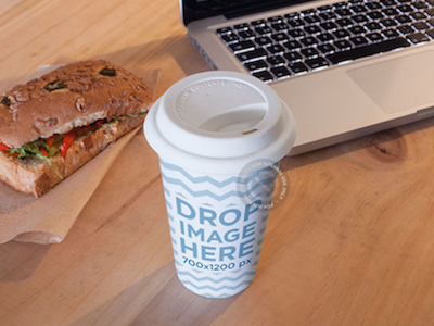 Coffee Cup Mockup Sitting Next to a Sandwich and a Macbook Pro