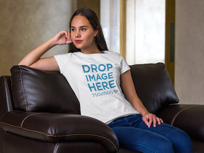 T-Shirt Mockup of a Young Woman Sitting on a Sofa digital marketing mockup generator mockup template mockup tools stock photo mockup stock photo template t shirt mockup t shirt mockup generator t shirt mockup template t shirt template visual marketing campaign web marketing