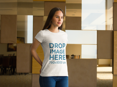 Young Woman Standing in Front of a Wall T-Shirt Mockup