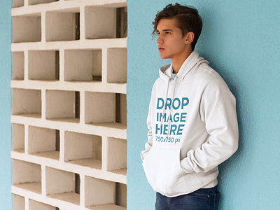 Young Man Leaning Against a Blue Wall Hoodie Mockup