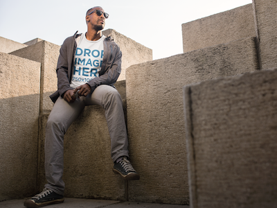 Download Black Man Sitting on a Modern Concrete Structure T-Shirt Mockup by Placeit on Dribbble