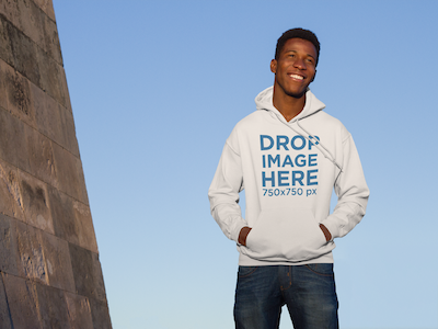 Hoodie Mockup of Guy Standing Next to a Monument