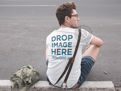 Tee Mockup Featuring a Young Hipster Man Sitting on a Sidewalk