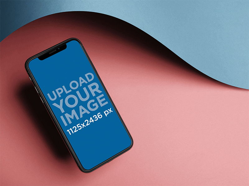 Iphone X Mockup Floating Angled Near A Curved Paper