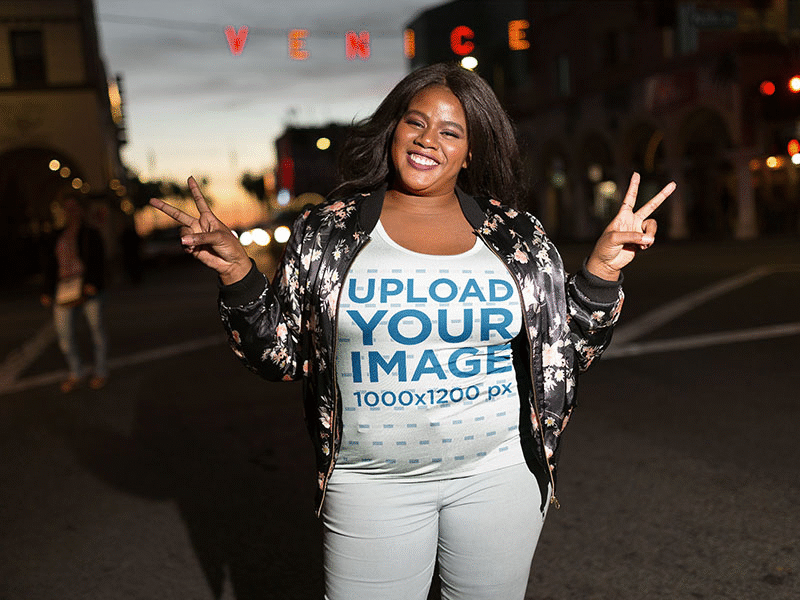 Black Girl Wearing A Plus Size Tshirt Mockup Near A Venice Sign apparel mockup graphic tee t shirt t shirt design t shirt mockup