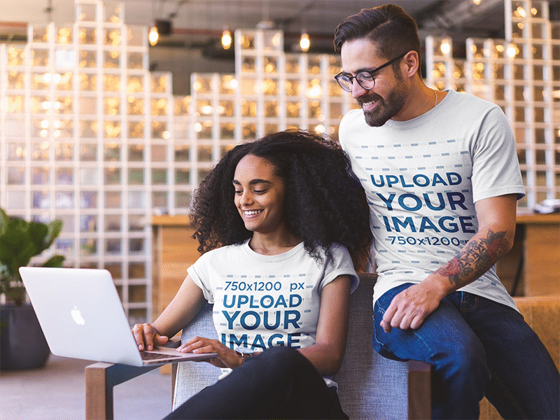 Smiling Coworkers Wearing T Shirts Mockup While Watching A Lapto apparel mockup graphic tee t shirt t shirt design t shirt mockup