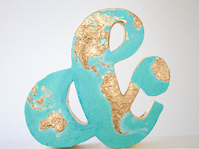 Wanderlust ampersand continents gold map sculpture topography travel world
