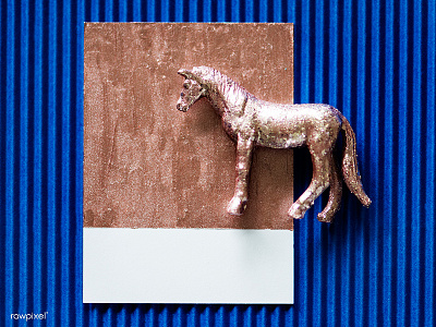 Tiny metallic horse on blue paper