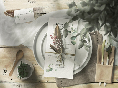 Wedding Invitation Cards With Feathers On A Table With Plates