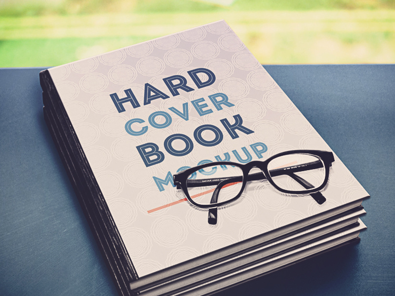 Hardcover Book Mockup book photo mockup psd bookcover glasses grass table pattern books