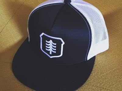 Brave Shield Trucker Hat apparel cap hat logo shield tree trucker hat