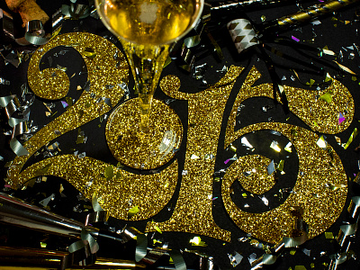 Happy New Year! and black confetti curves cut paper glitter gold lettering metallic numbers numerals serif