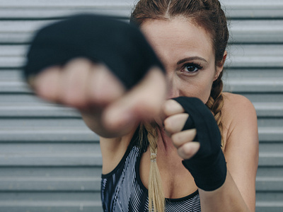 Sportswoman looking at camera and punching branding design icon photo