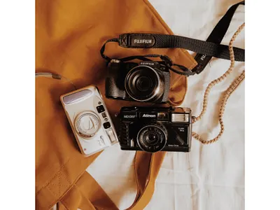 Three Cameras on the Top of Brown Leather Bag 3 camera brown bag camera leather bag
