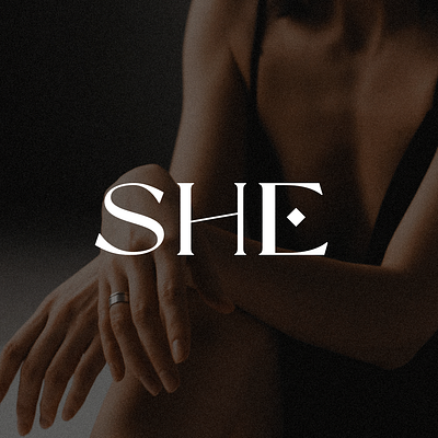 SHE logo