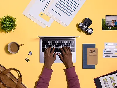 Photographer's Desk Essentials aerial camera coffee flats hands invoice laptop memory card notebook photography