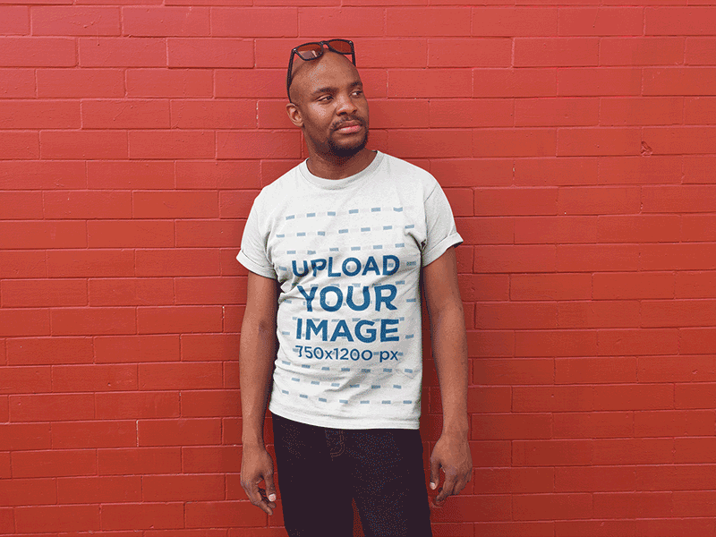 T-Shirt Mockup of a Bald Man Posing Against a Red Wall mockup generator mockup tools tshirt design tshirt mockup