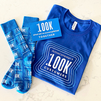 100K Customer employee swag pack animation apparel branding celebration employee gift knit logo milestone pattern print pulse repeating pattern shirt socks swag wearables