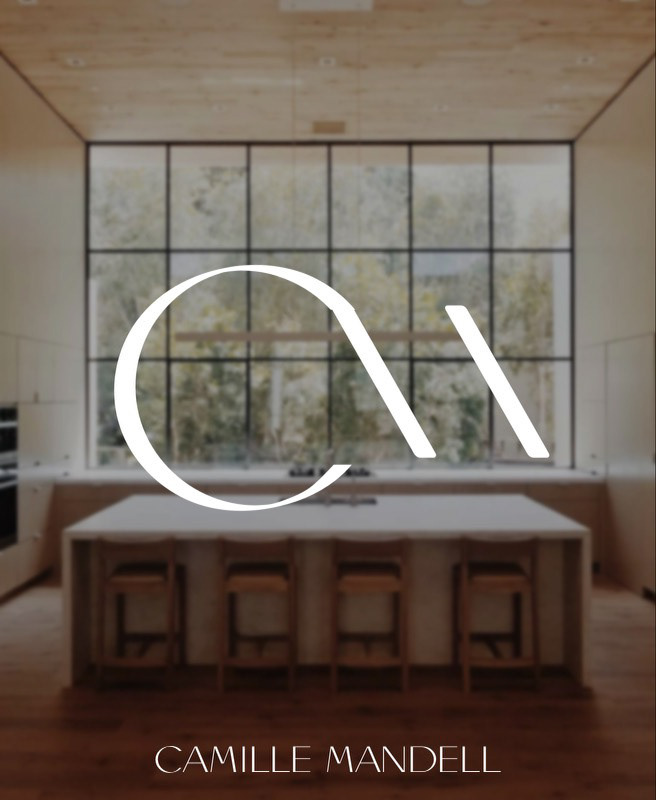 CM logo in focus in front of a modern kitchen