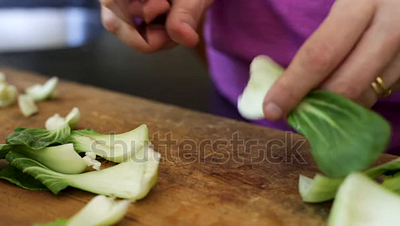 Prepping and cutting bok choy with a knife on a cutting board gourmet