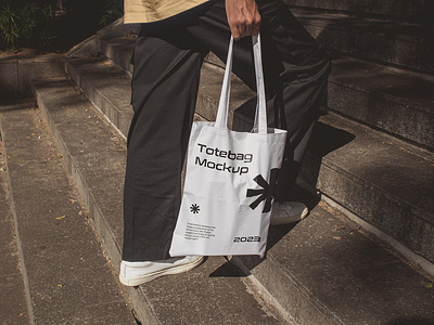 Man Holding Totebag Mockup apparel bag canvas fabric grocery hand bag man minimalism mockup pouch product realistic shopping showcase streetwear totebag urban walking